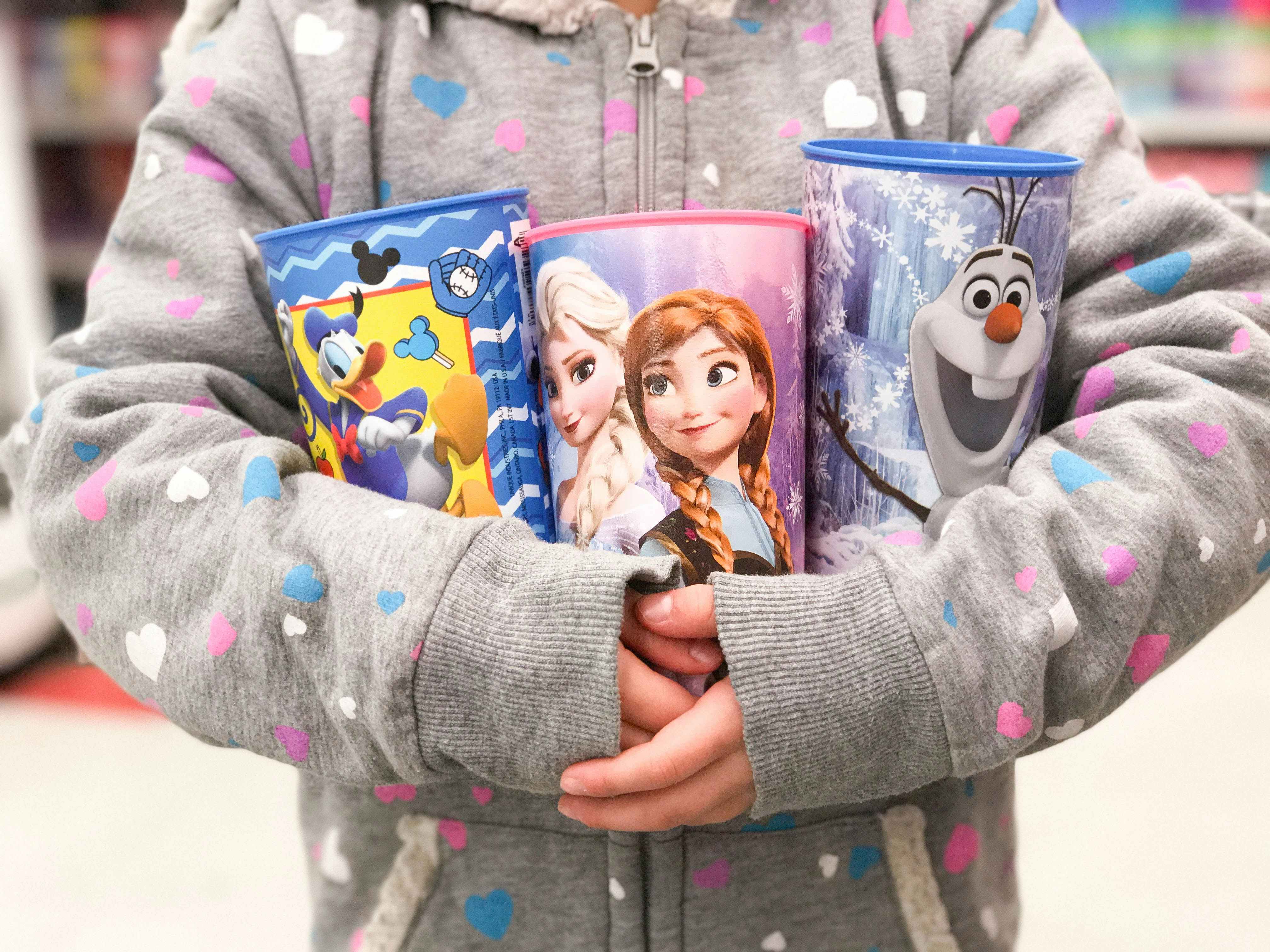 someone holding disney cups