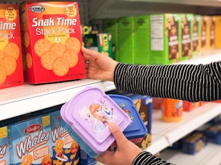 someone holding sandwich container and grabbing chips