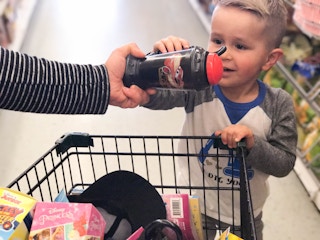 someone handing boy water bottle