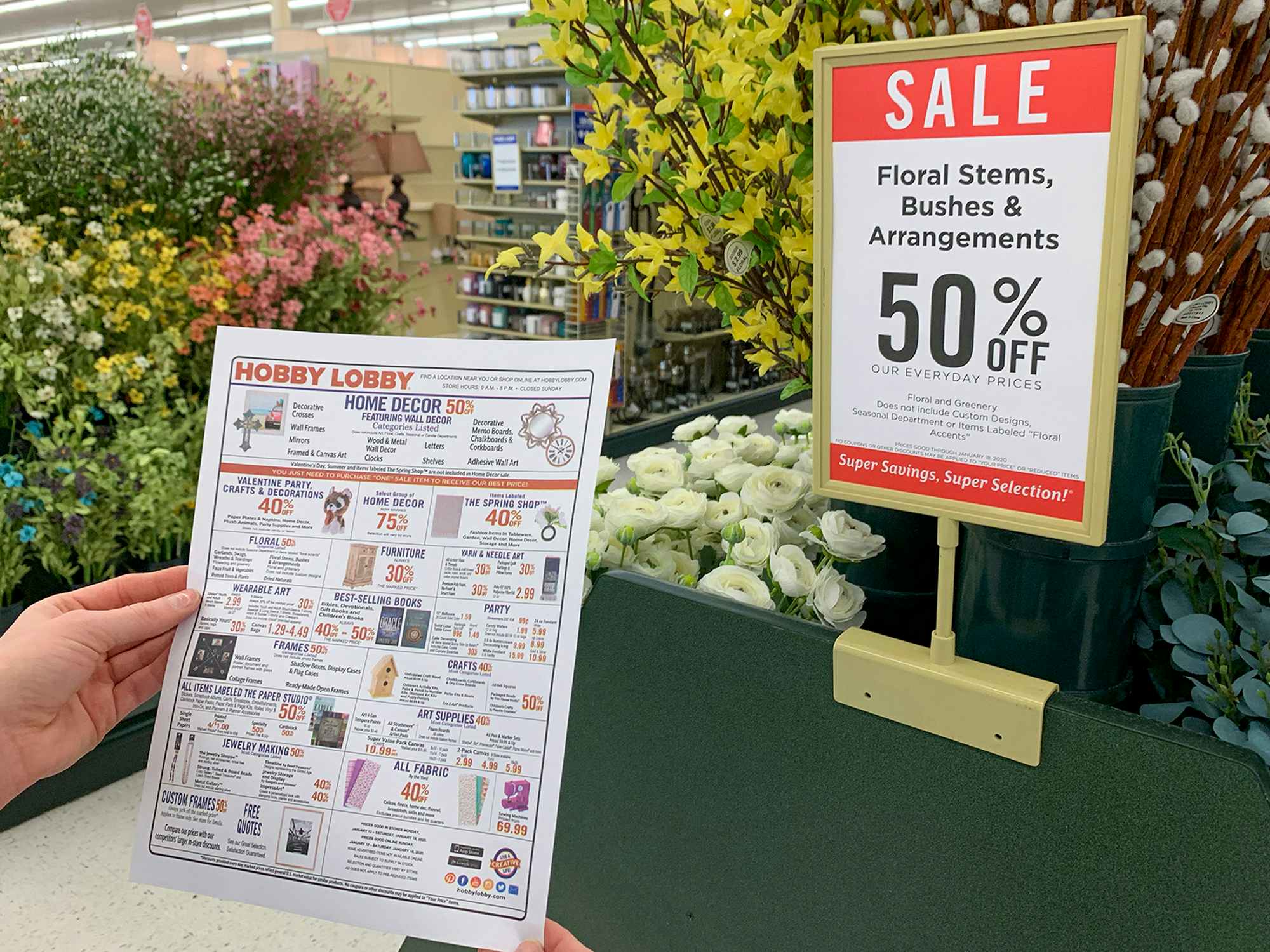 a person holding up a hobby lobby sale flyer