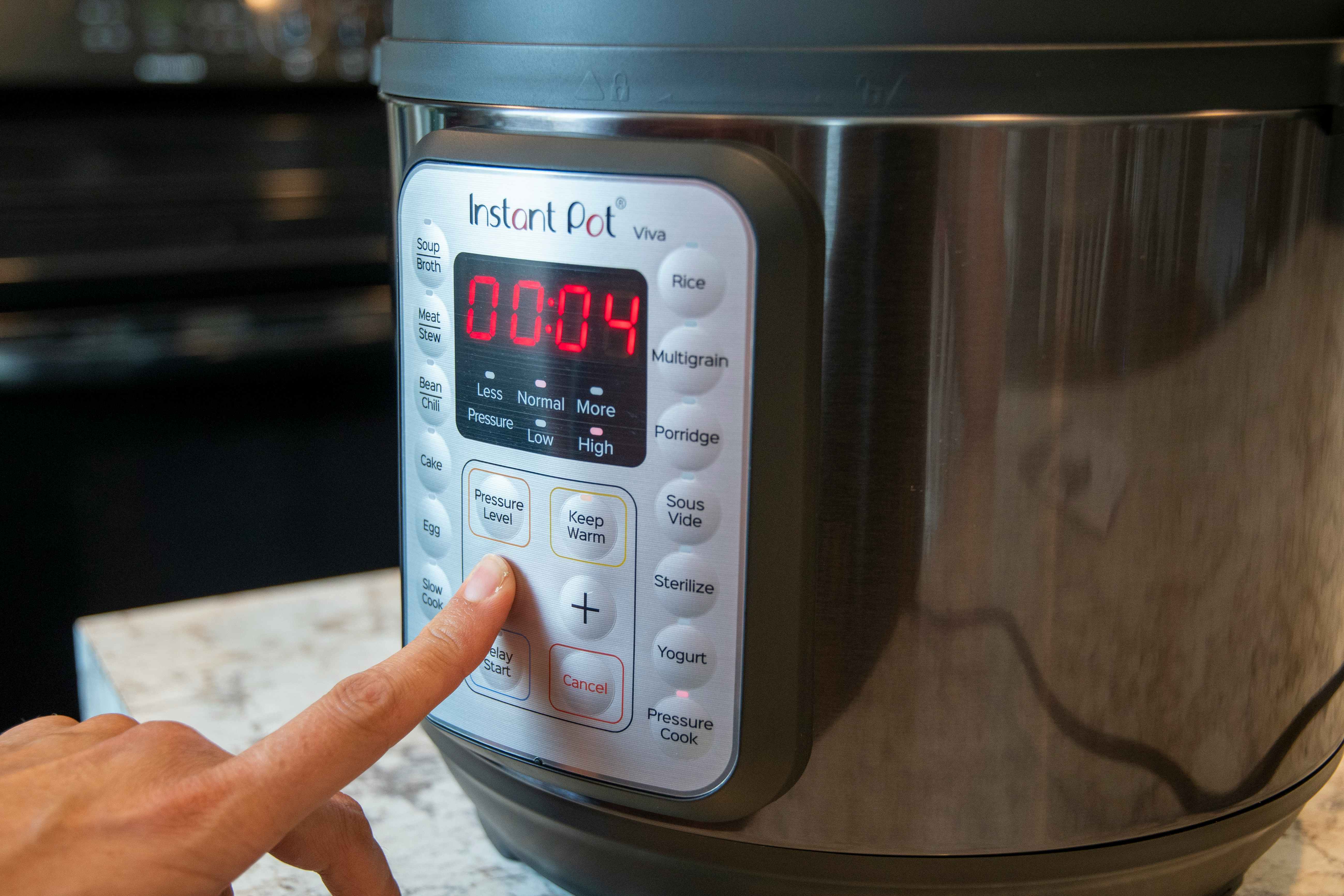 A person adjusting the cook timer on the control panel of an instant pot