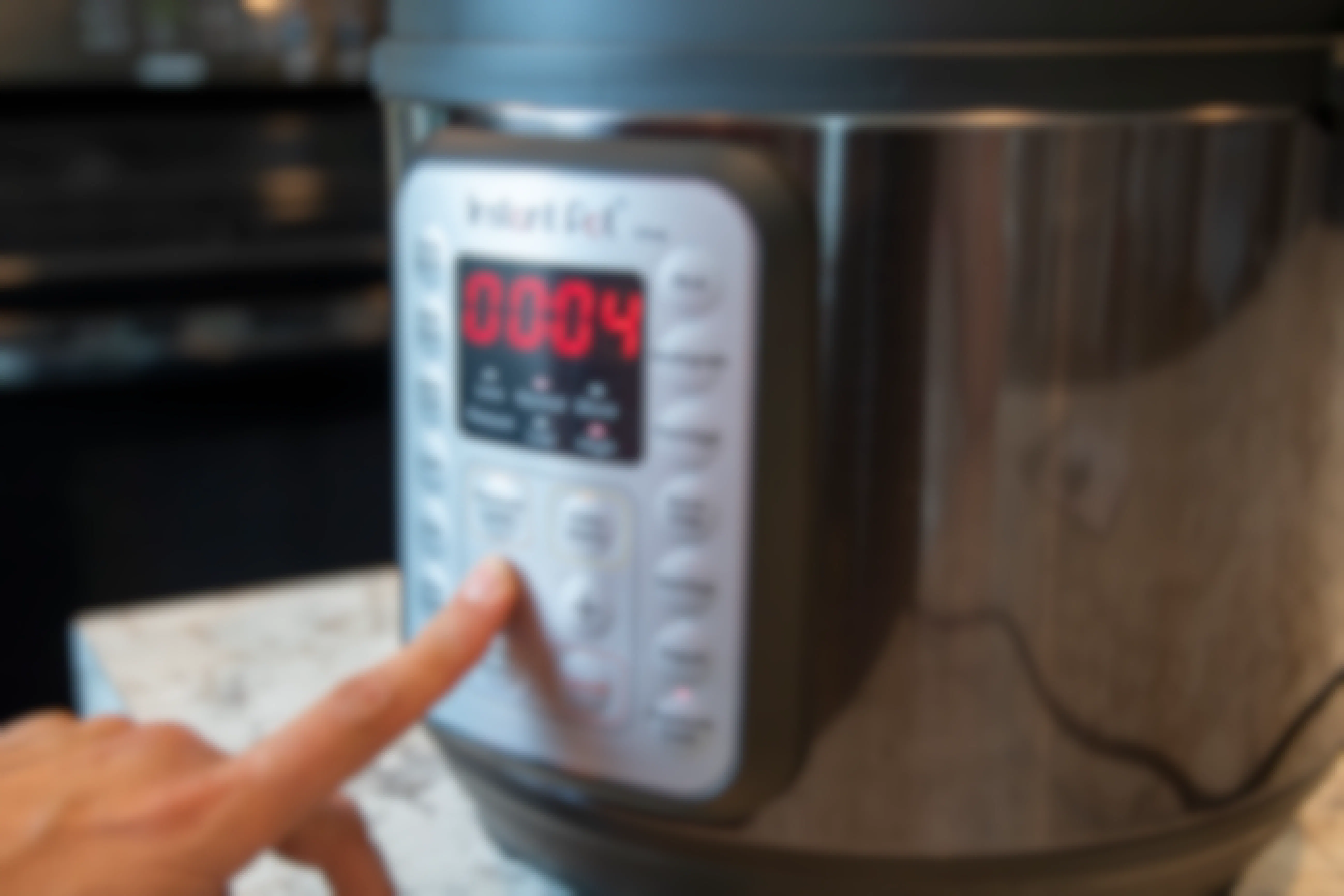 A person adjusting the cook timer on the control panel of an instant pot