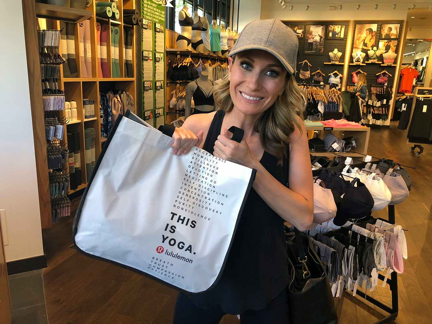 Woman holding a Lululemon shopping bag in store.