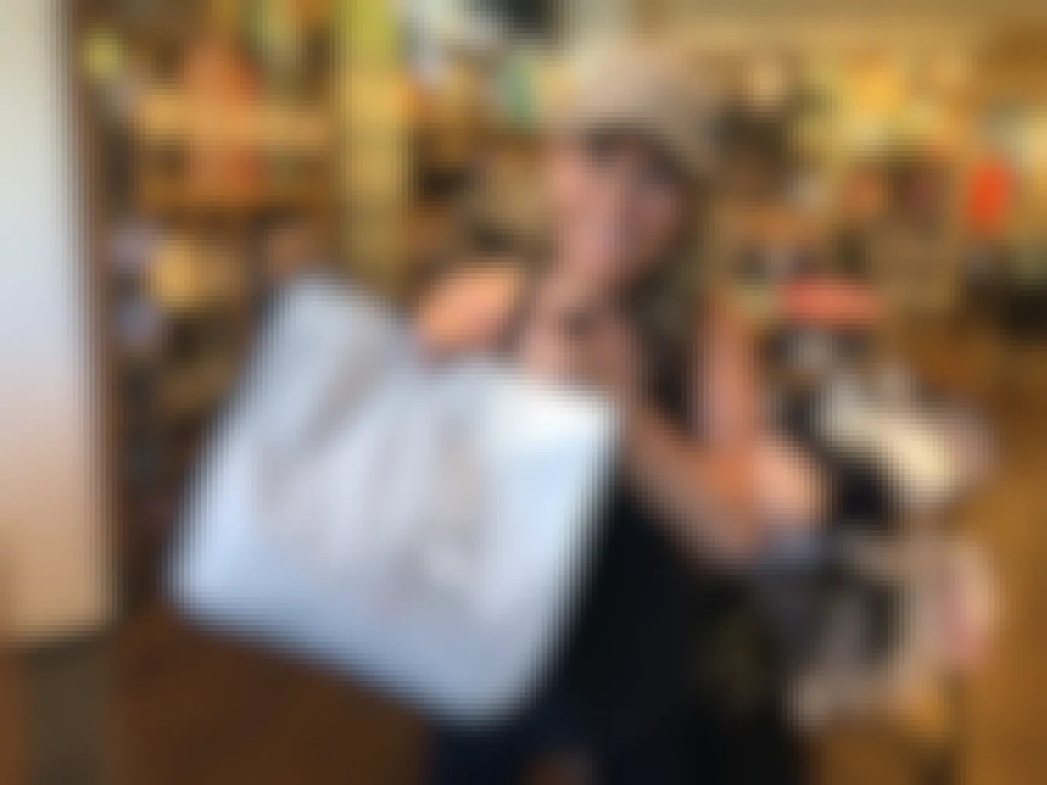 Woman holding up a Lululemon bag while smiling