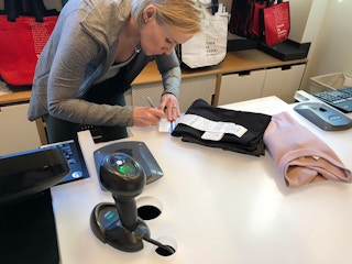An employee writing on a receipt at Lululemon