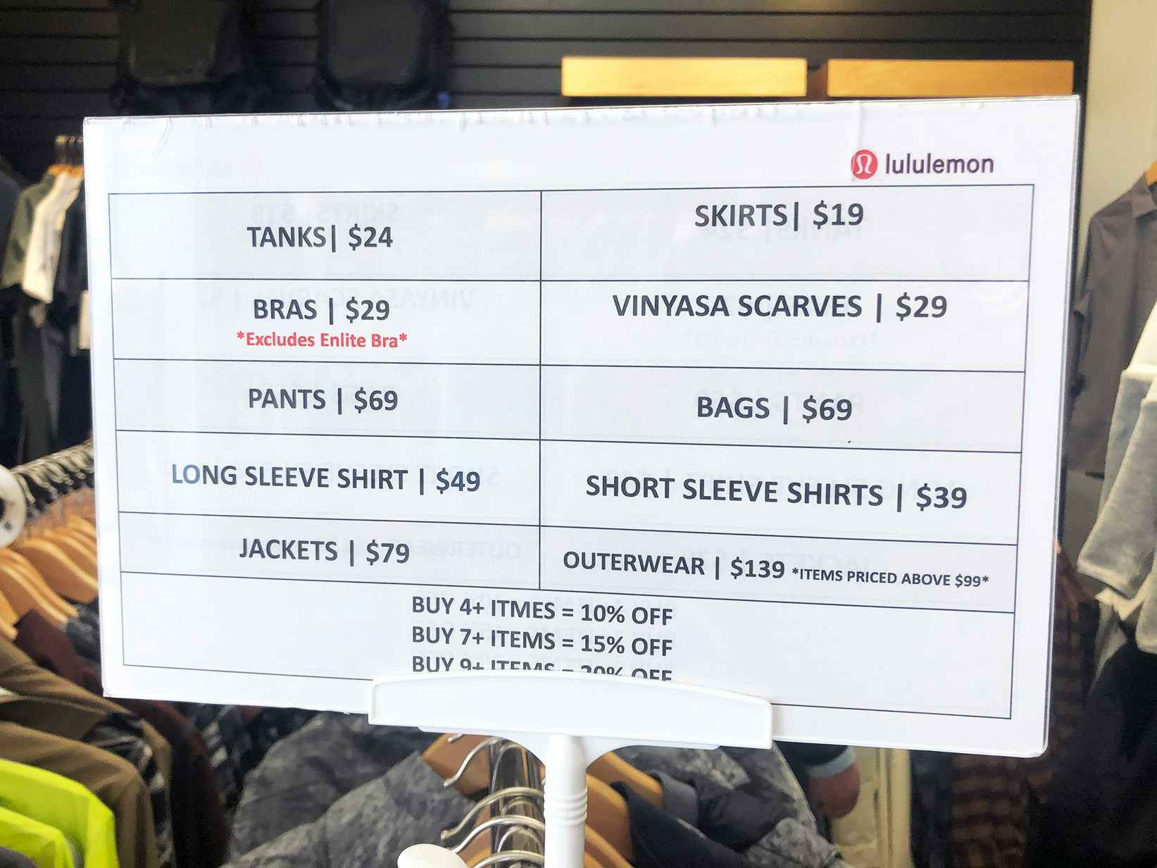 Sign inside a Lululemon outlet showing discounts on bras, tanks, bags and more