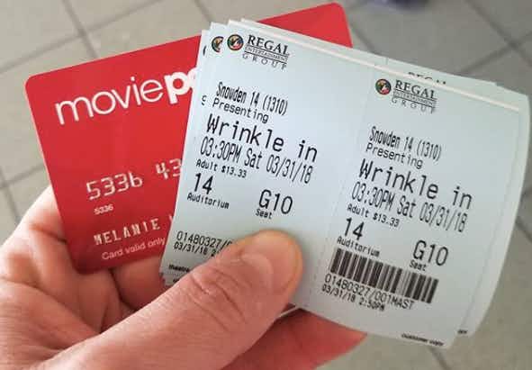 A person holding an old MoviePass card and tickets to a movie.