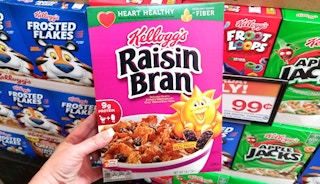 Hand holding a box of Raisin Bran Cereal