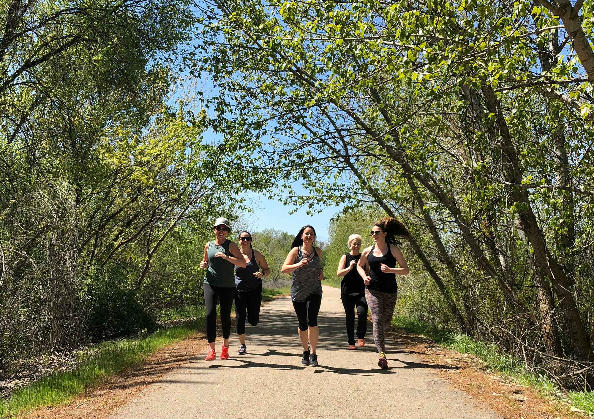 Group of young women running together outside in nature
