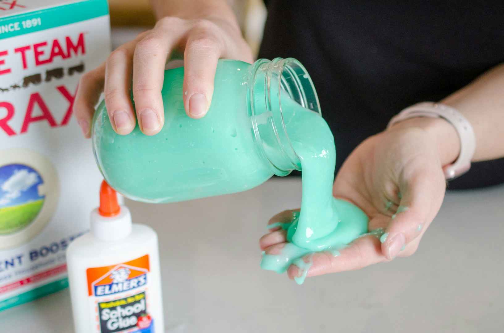 Woman pouring homemade slime into her hand.