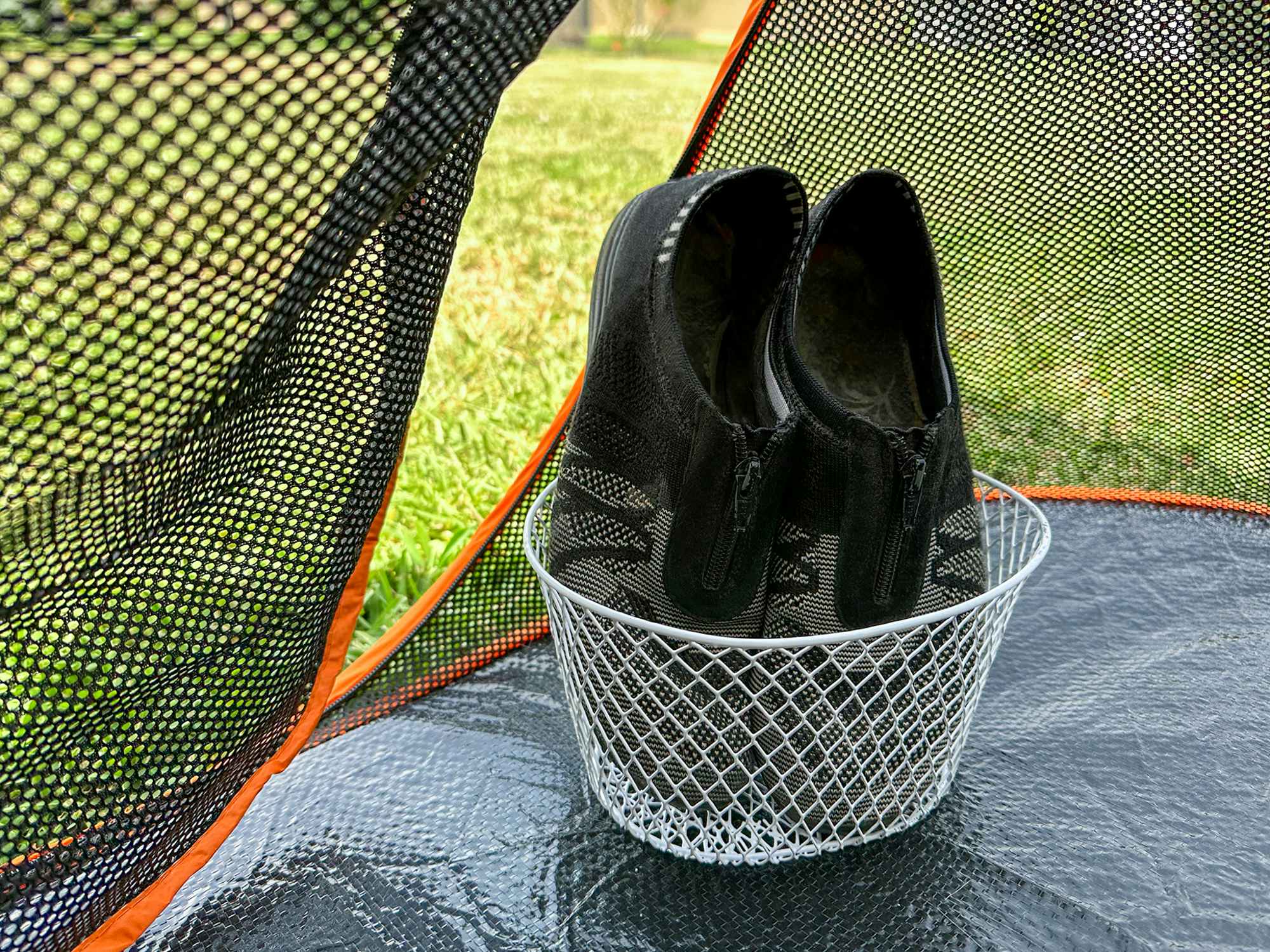 Shoes in a basket on the inside of a tent