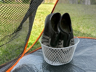 Shoes in a basket on the inside of a tent