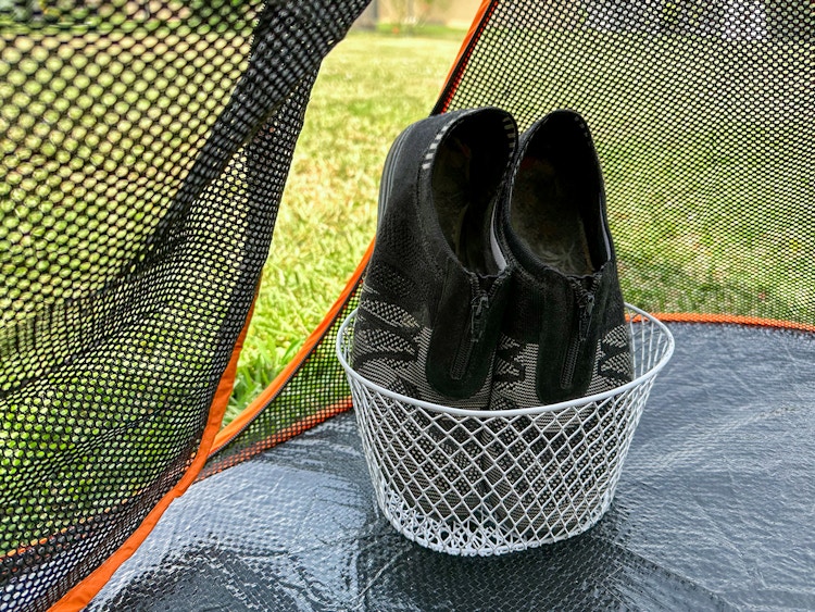 Shoes in a basket on the inside of a tent