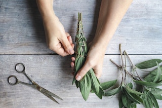 Someone wrapping bundles of herbs with string
