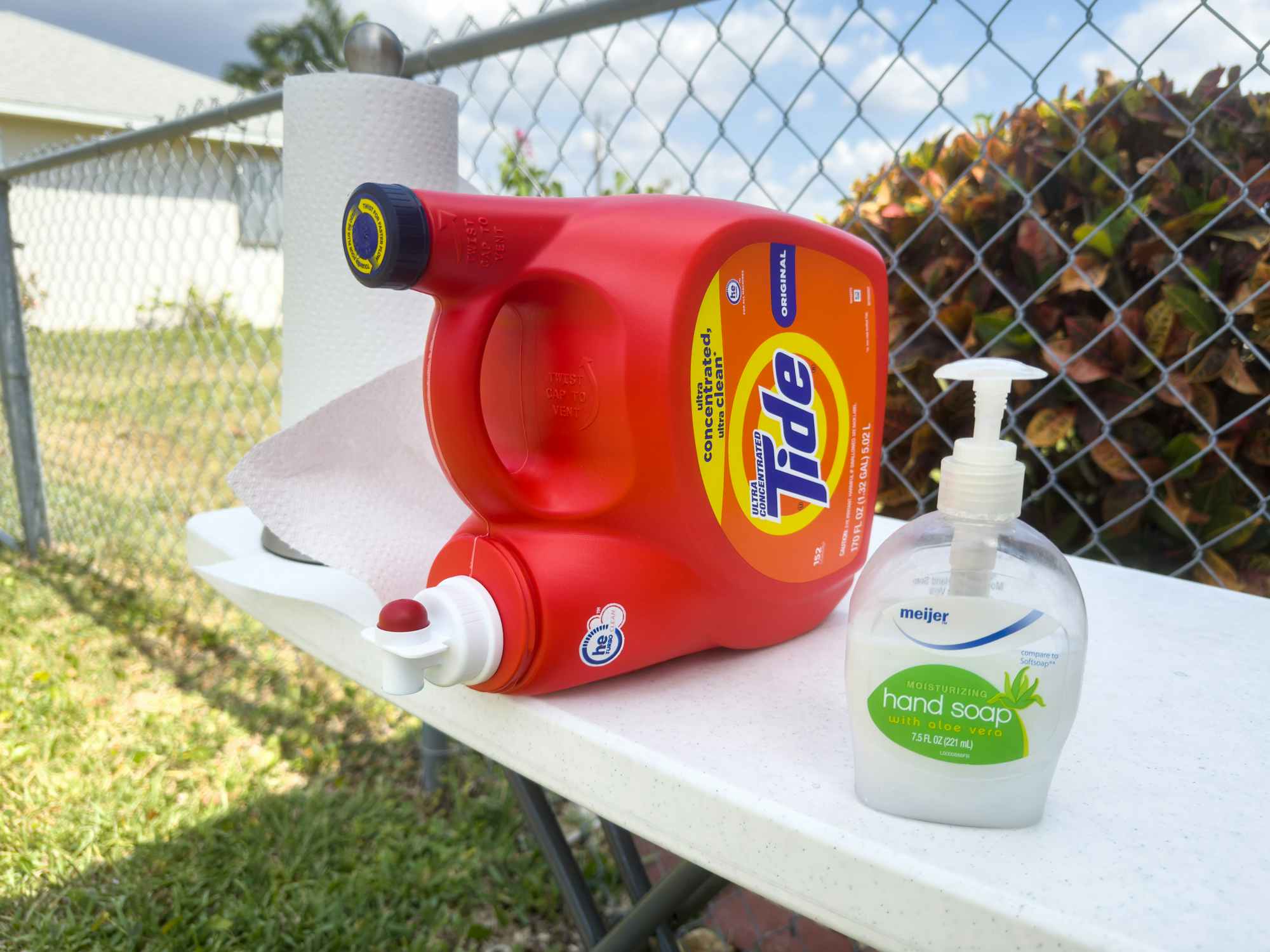 A laundry detergent container set up with soap and paper towels as a DIY hand washing station