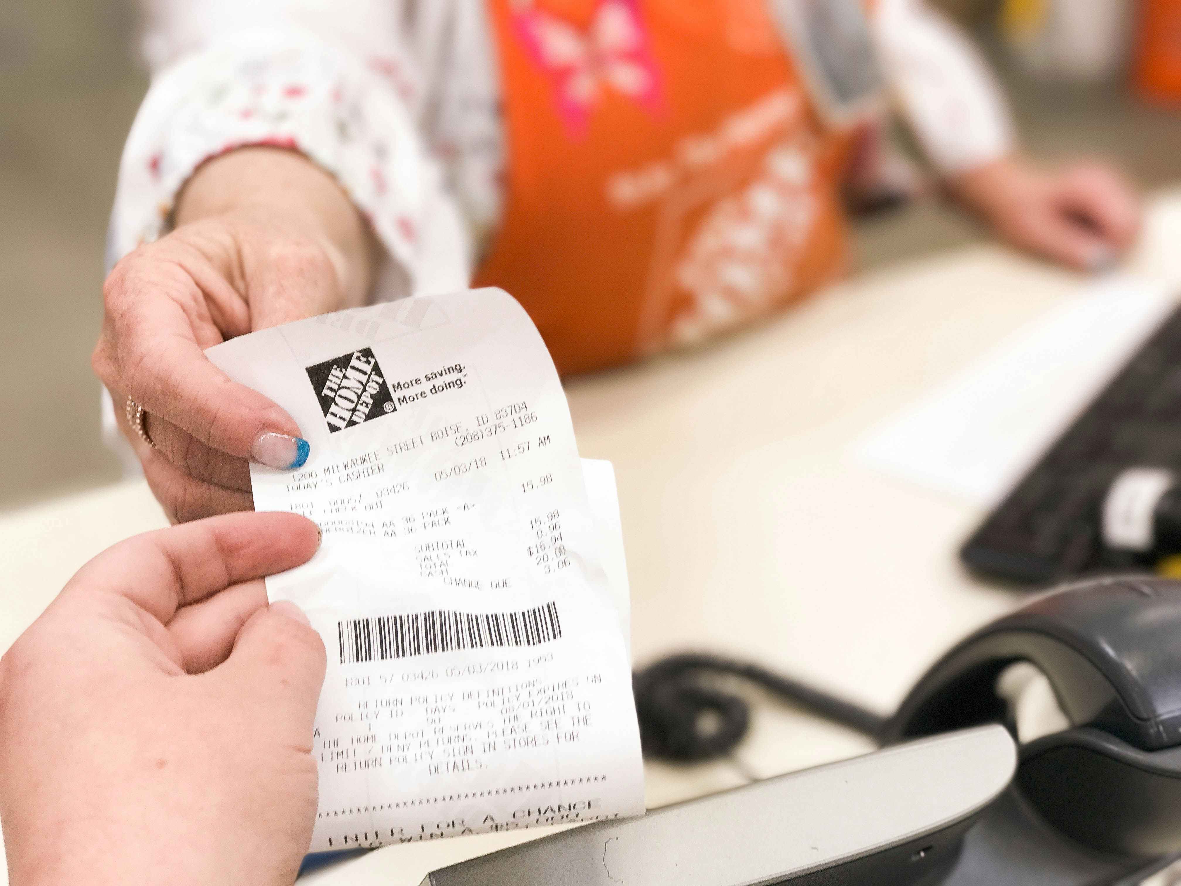 A person handing a customer service agent a receipt.
