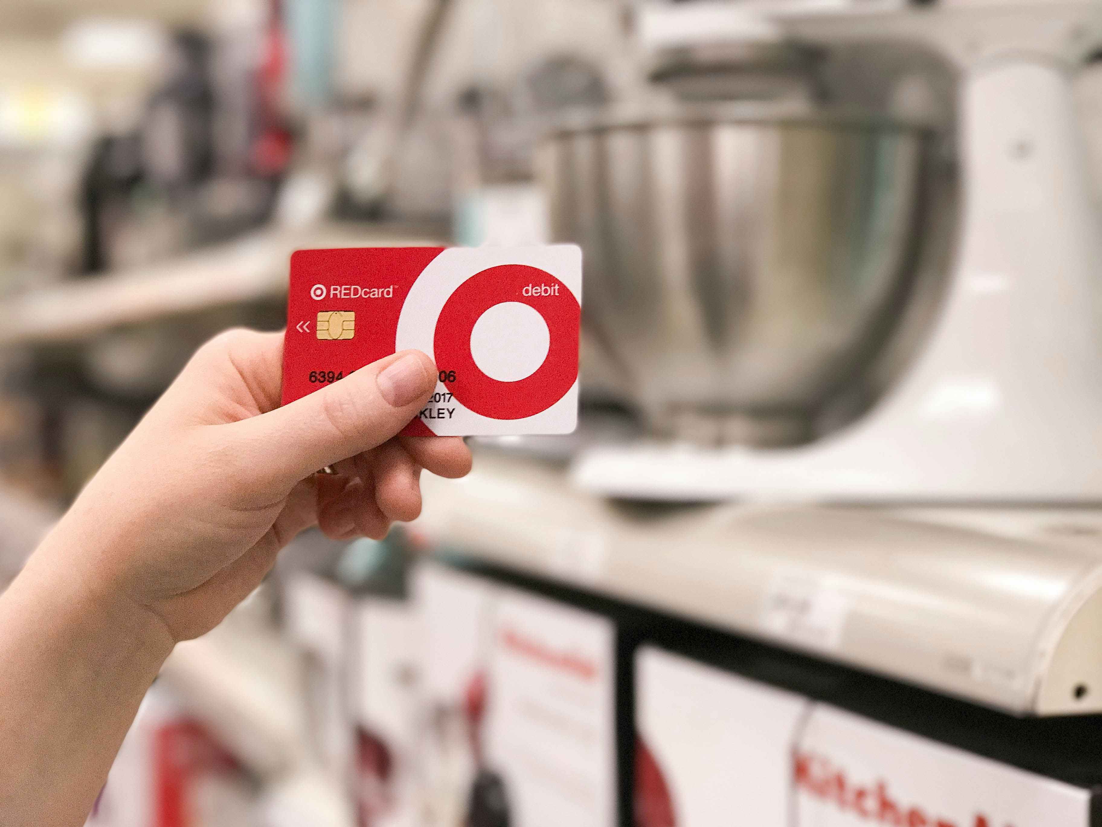 A Target Red card is held in front of Kitchenaid mixers at Target.
