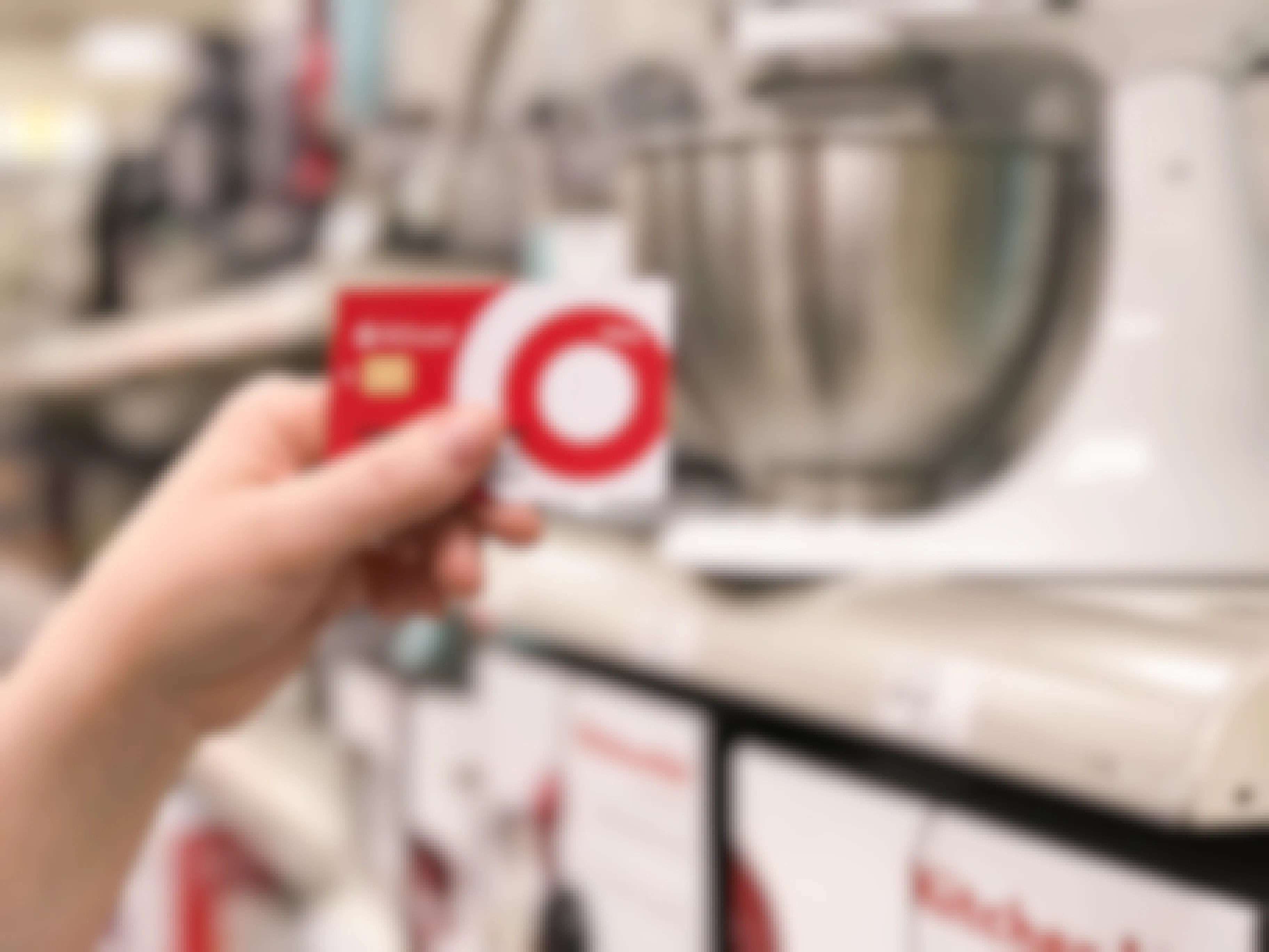 A Target Red card is held in front of Kitchenaid mixers at Target.