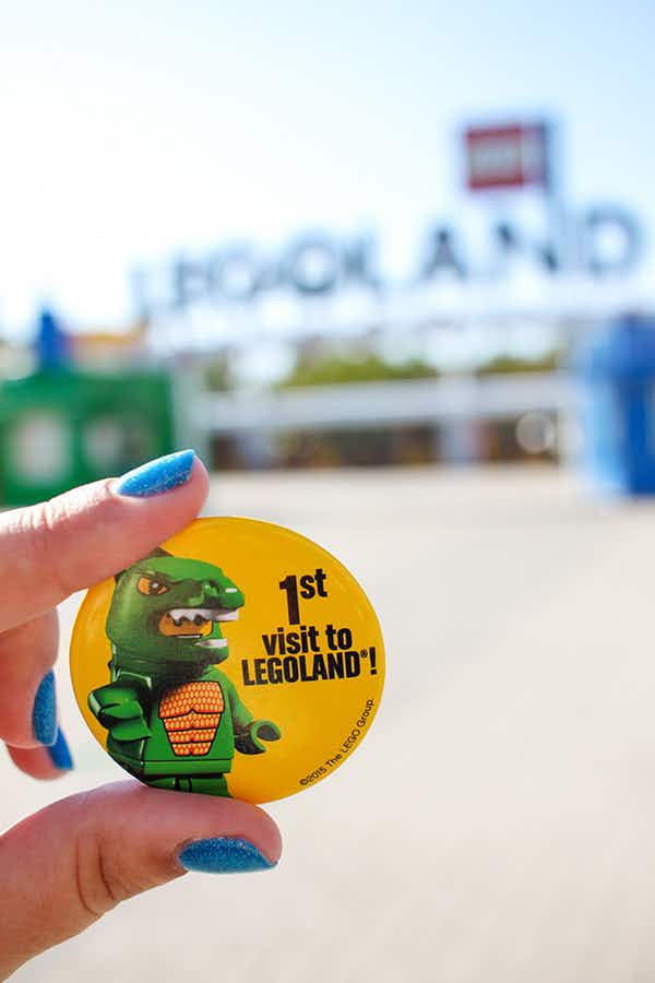 someone holding first visit to legoland pin
