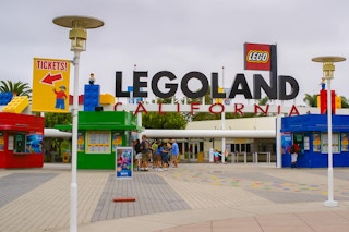 the entrance to LEGOLAND California with visitors waiting in line at one of the ticket booths