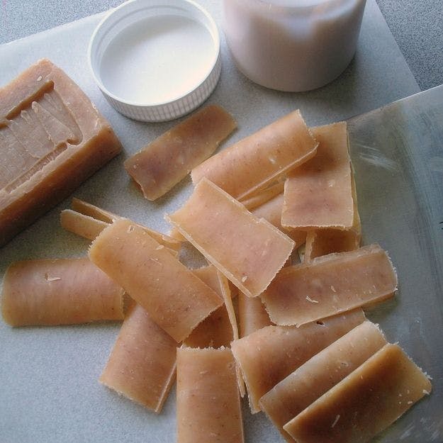 A bar of soap that has been peeled into small one-use pieces with a vegetable peeler.