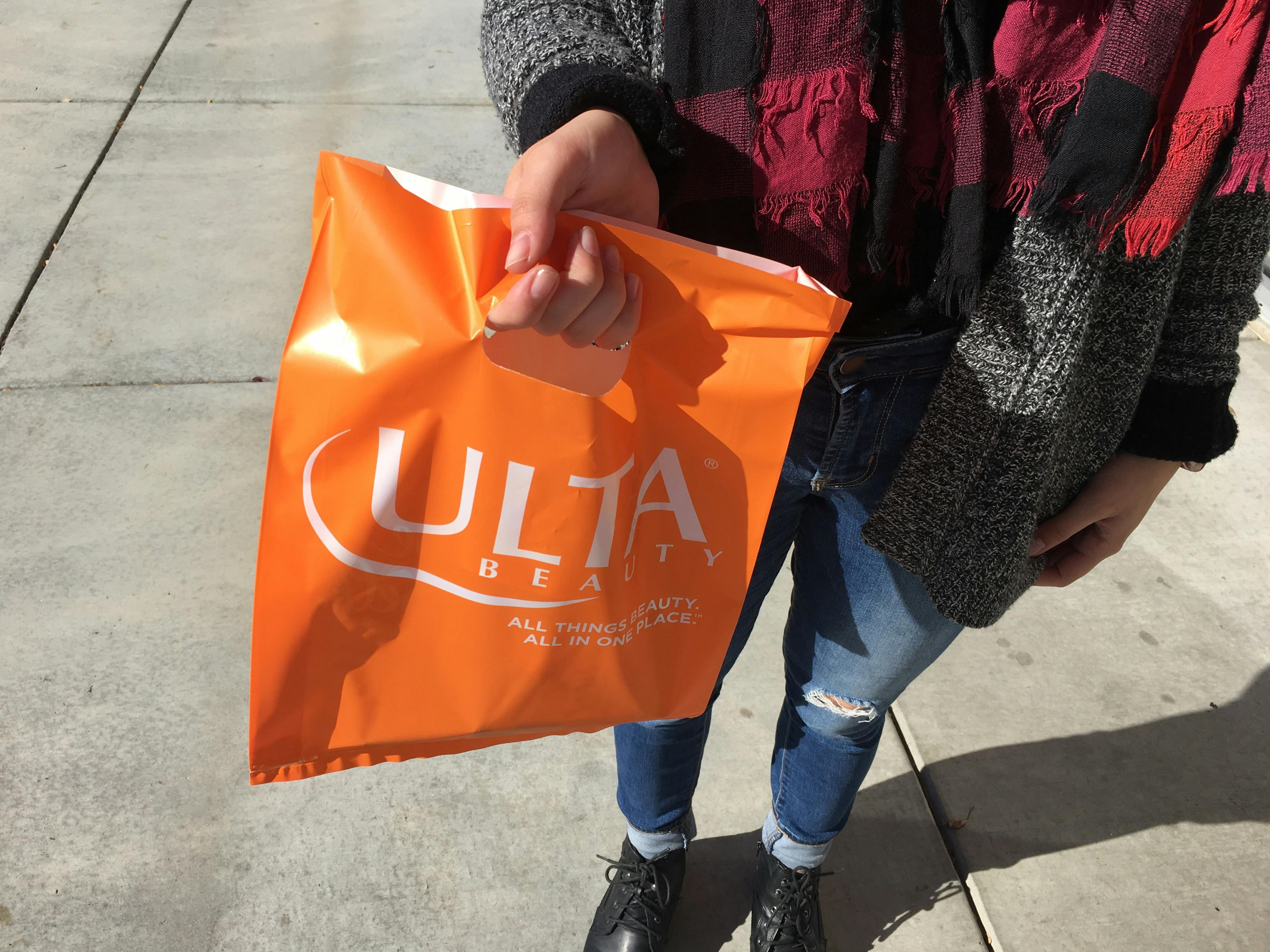 lady holds orange ulta bag 