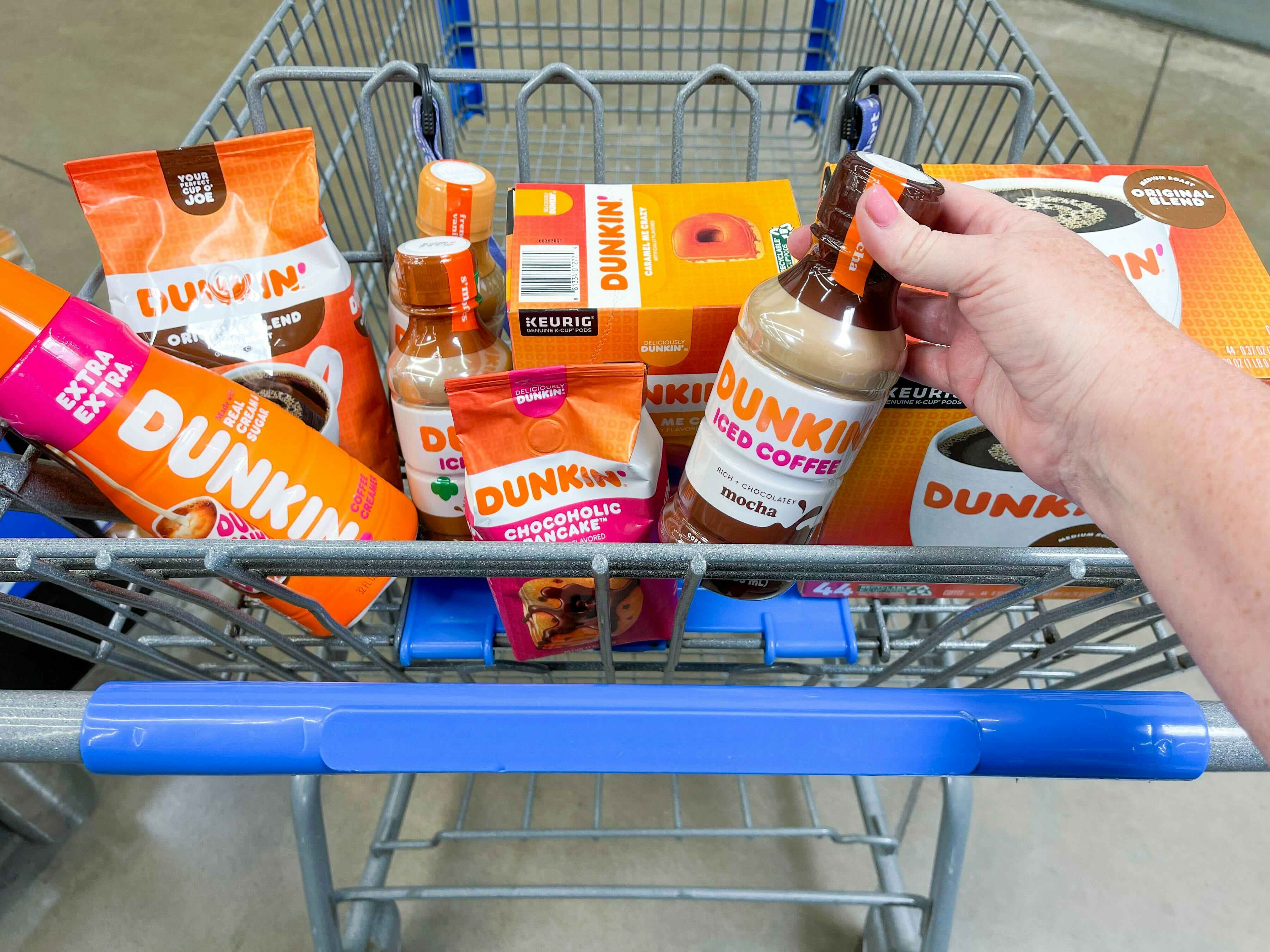 A Walmart shopping cart basket full of the different Dunkin brand items that are available at Walmart.