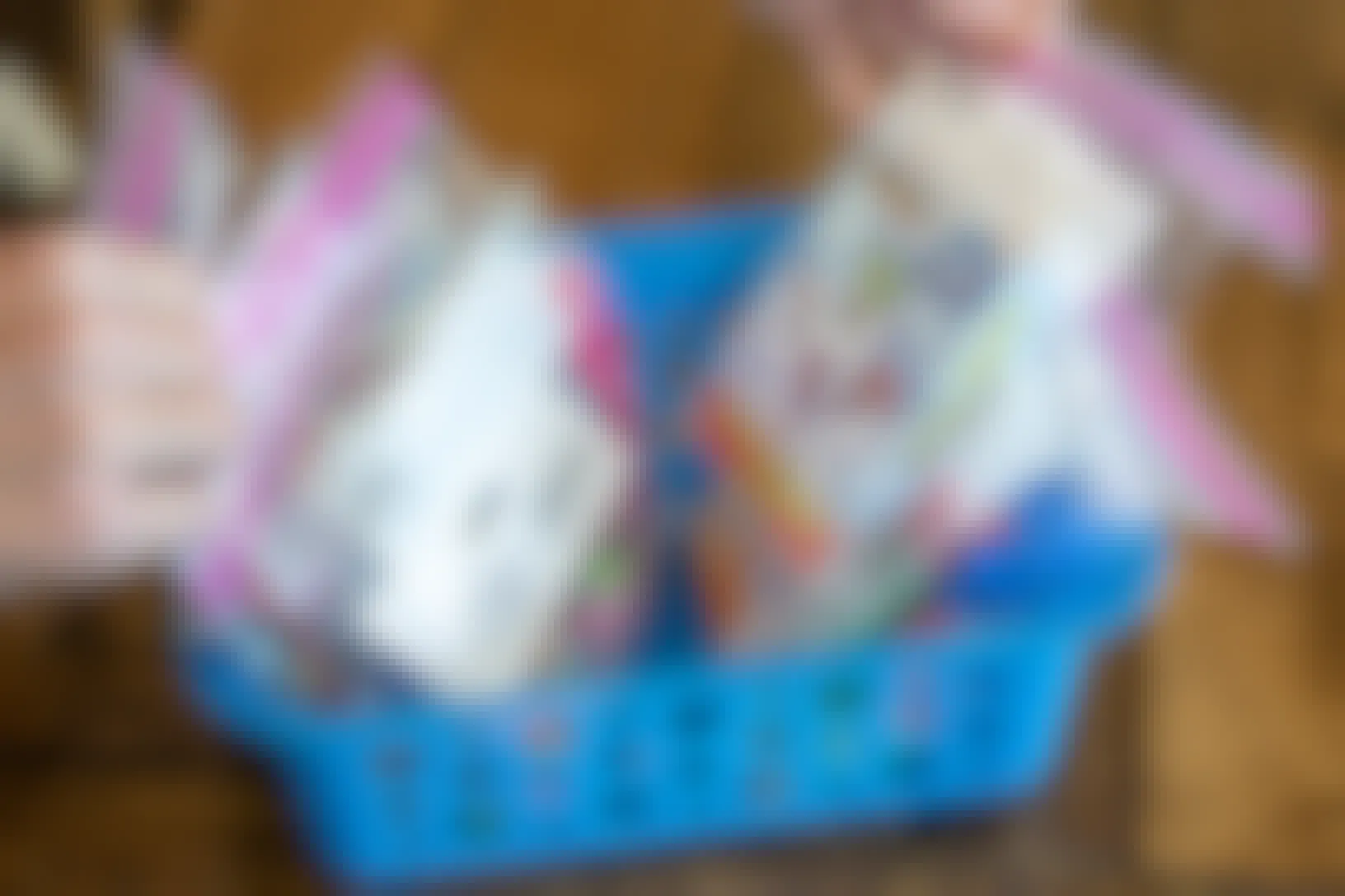 A person's hands going through several ziploc bags of toys sitting in a basket.