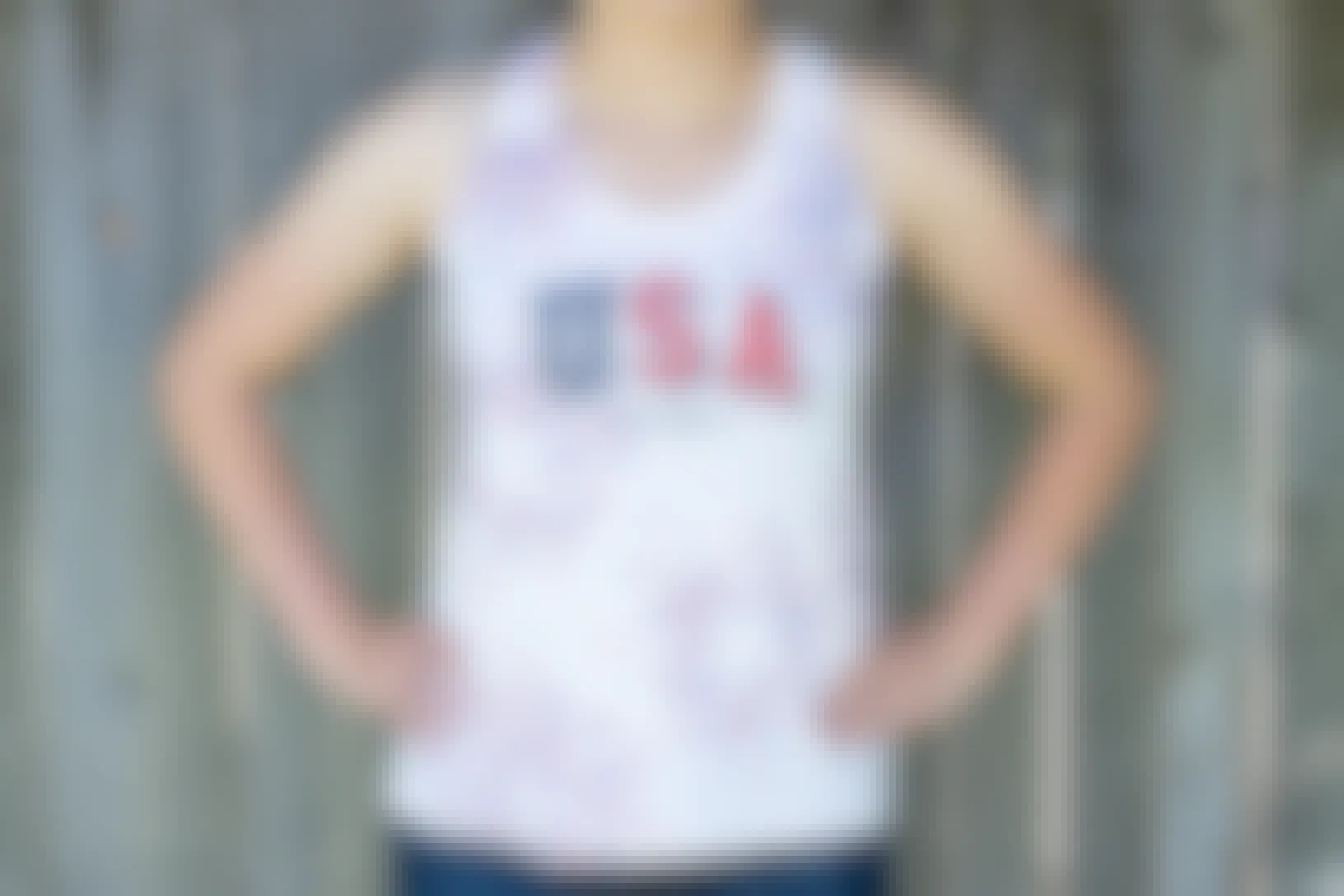 A person wearing a white Old Navy USA tank top with stars stenciled on in red and blue.