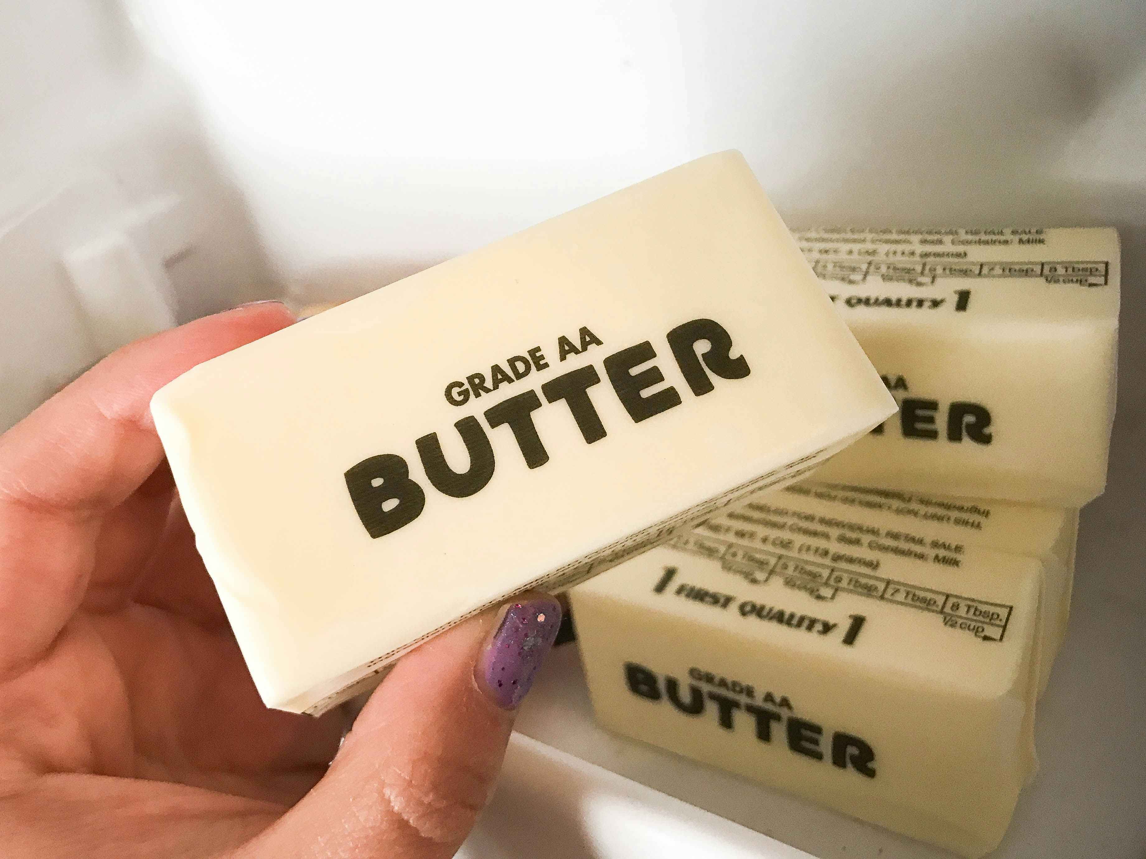 A person holding a stick of butter.