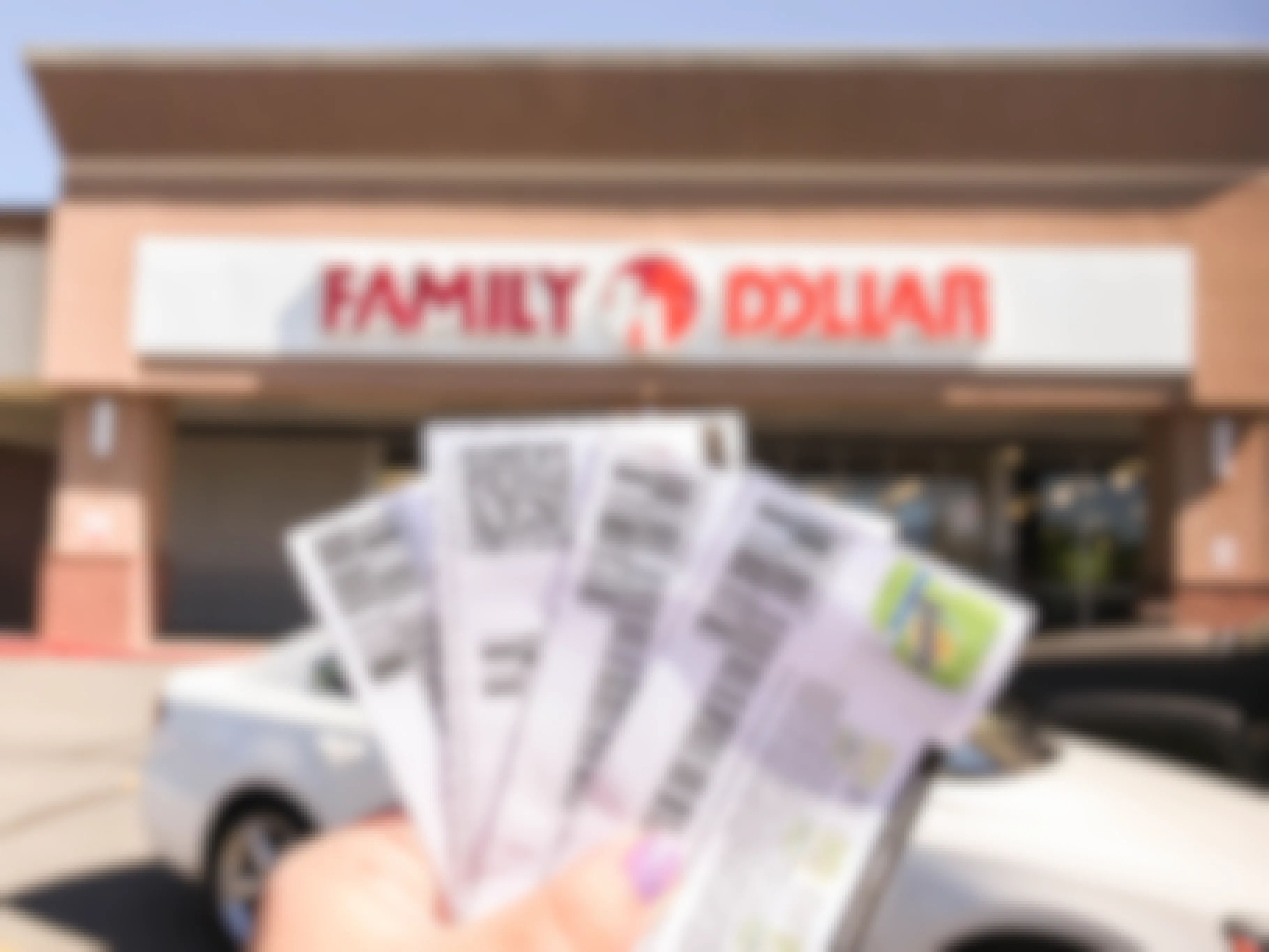 Woman holding four manufacturer coupons in front of a Family Dollar store