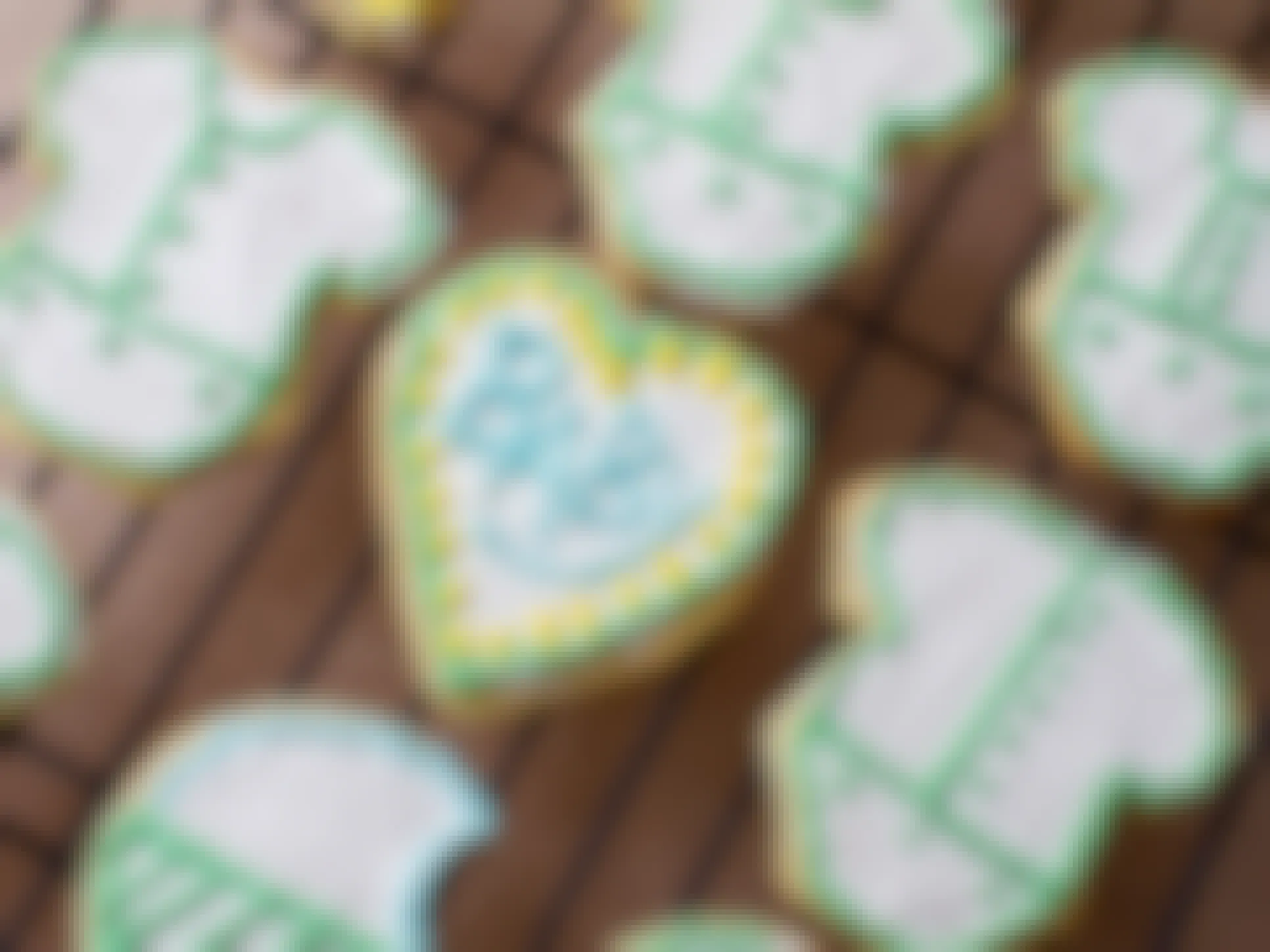 Cookies decorated for a baby announcement sitting on a rack.