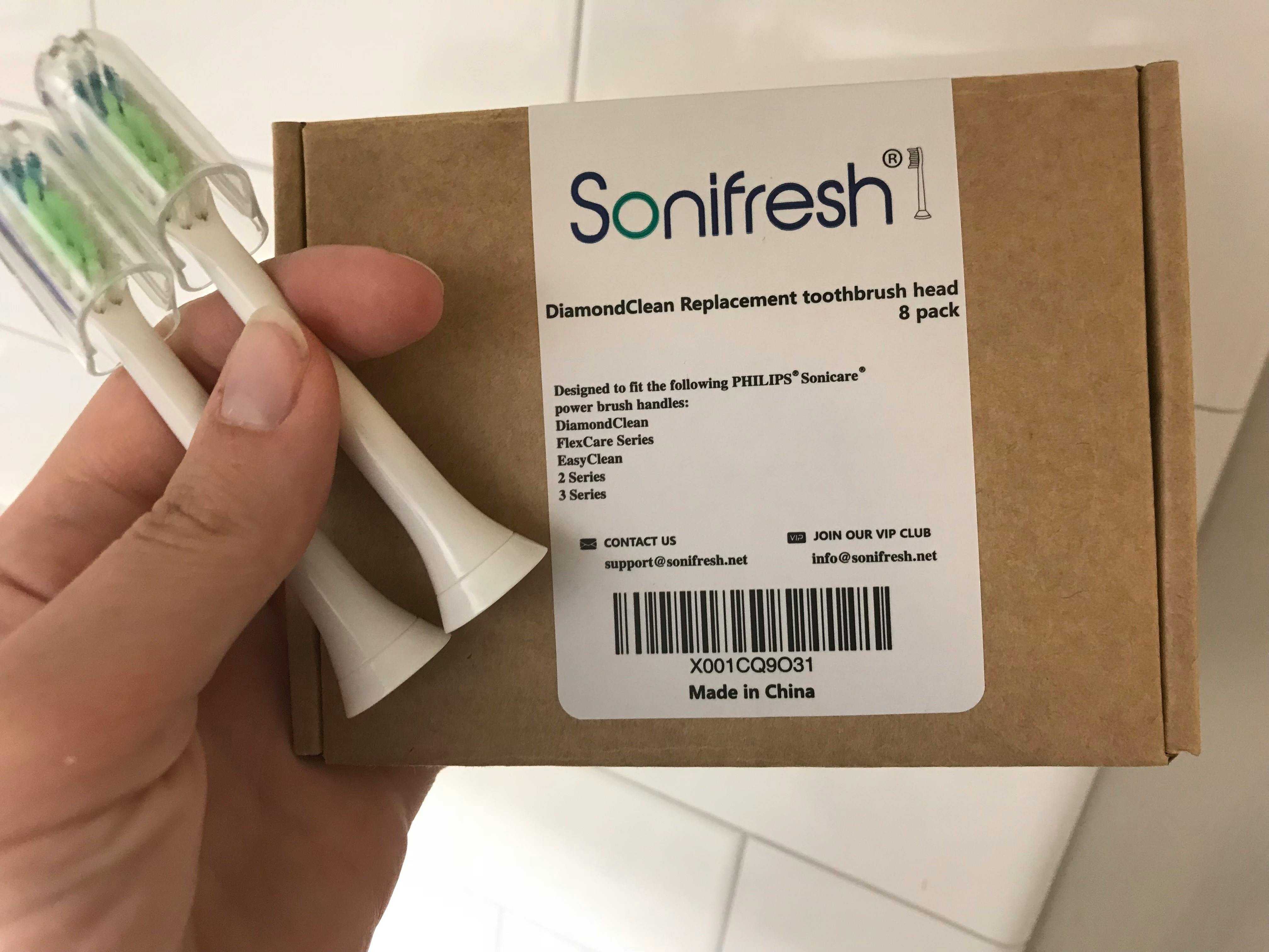 someone holding replacement toothbrush heads and a sonifresh box