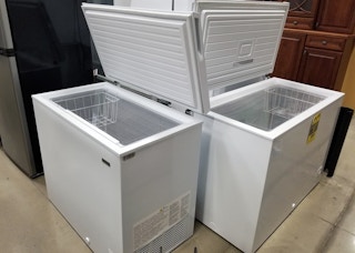 Two chest freezers open, side-by-side.