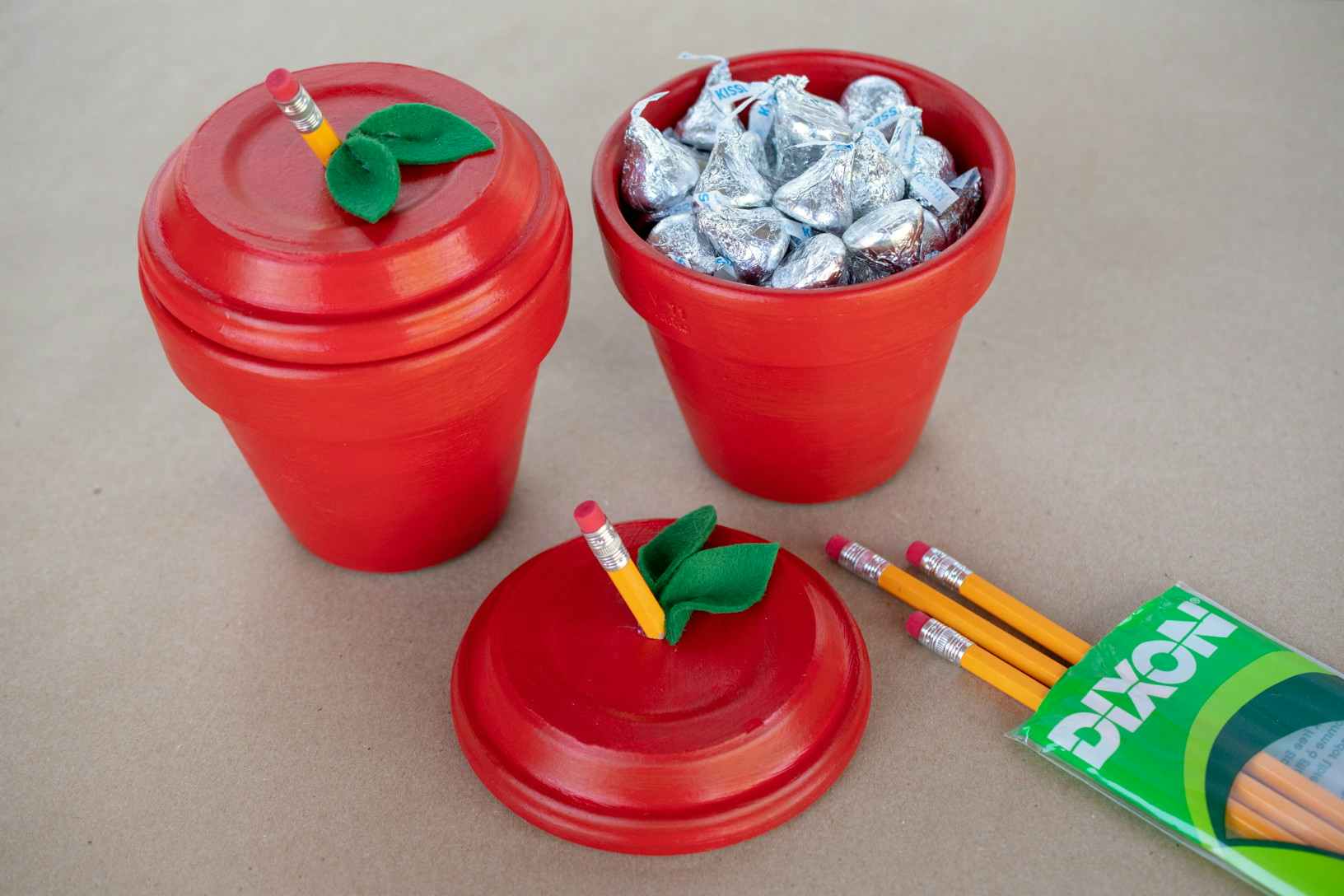Mini terracotta pots crafted to look like red apples and filled with Hershey's kisses.