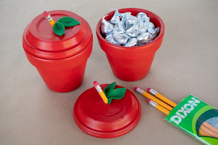 Mini terracotta pots crafted to look like red apples and filled with Hershey's kisses.