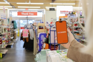 a person holding up a phone in the family dollar