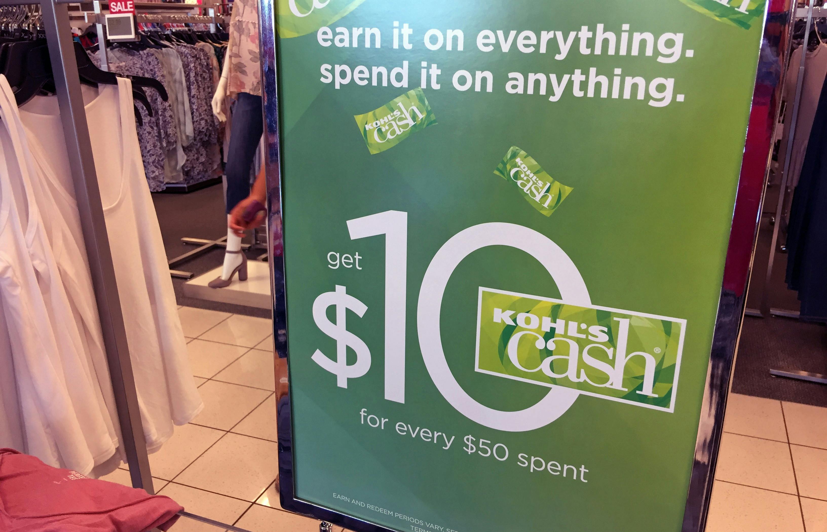 Green sign at Kohl's store advertises $10 Kohl's cash you can spend on anything in the store.