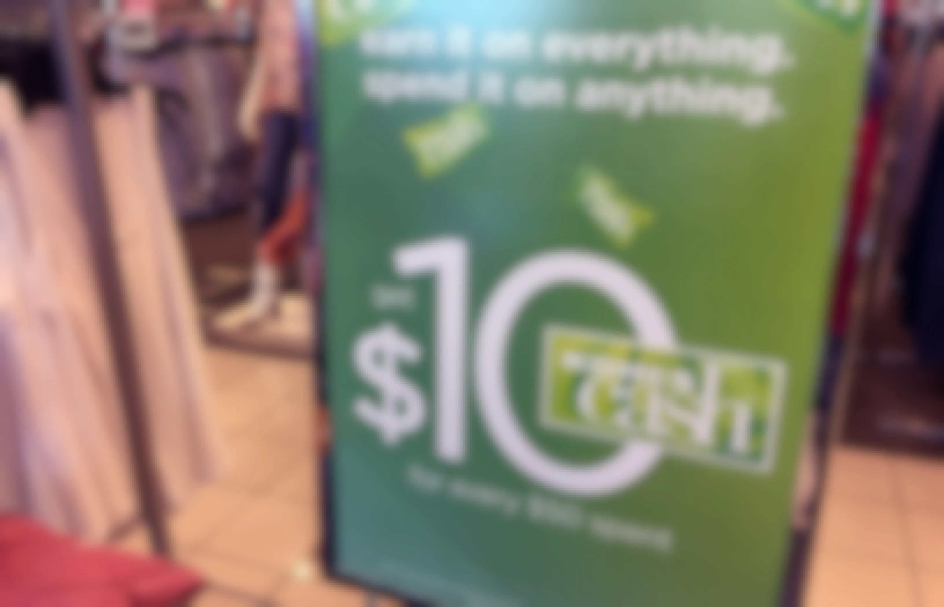 Green sign at Kohl's store advertises $10 Kohl's cash you can spend on anything in the store.