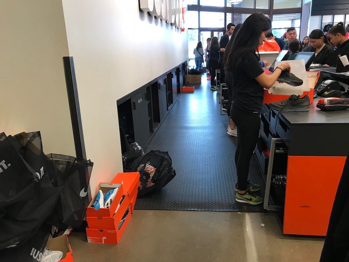 A view behind the checkout counter at a Nike Factory store with some shoe boxes stacked on the floor.