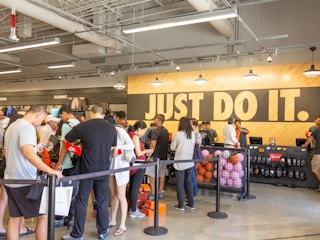 A long line of customers in front of the checkout counter at a Nike store.