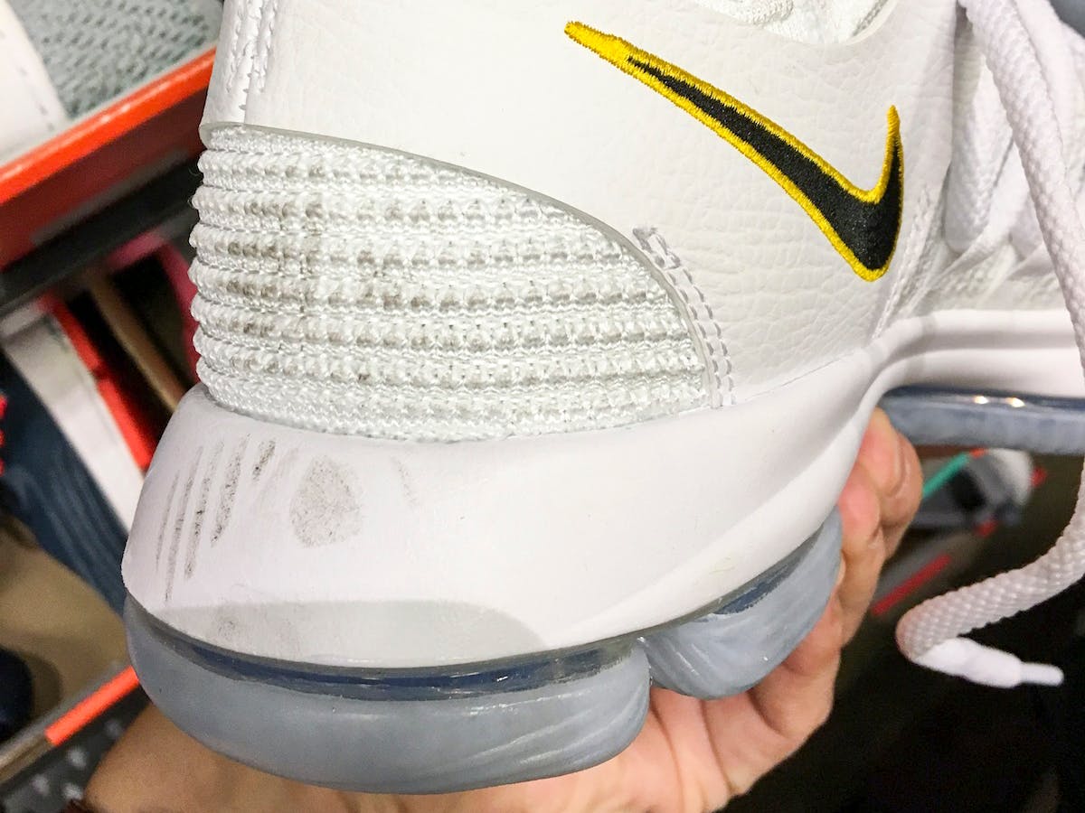 A close-up of a Nike running shoe with scuff marks on the back.