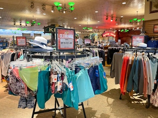 Multiple clearance racks on the Cabela's sales floor.