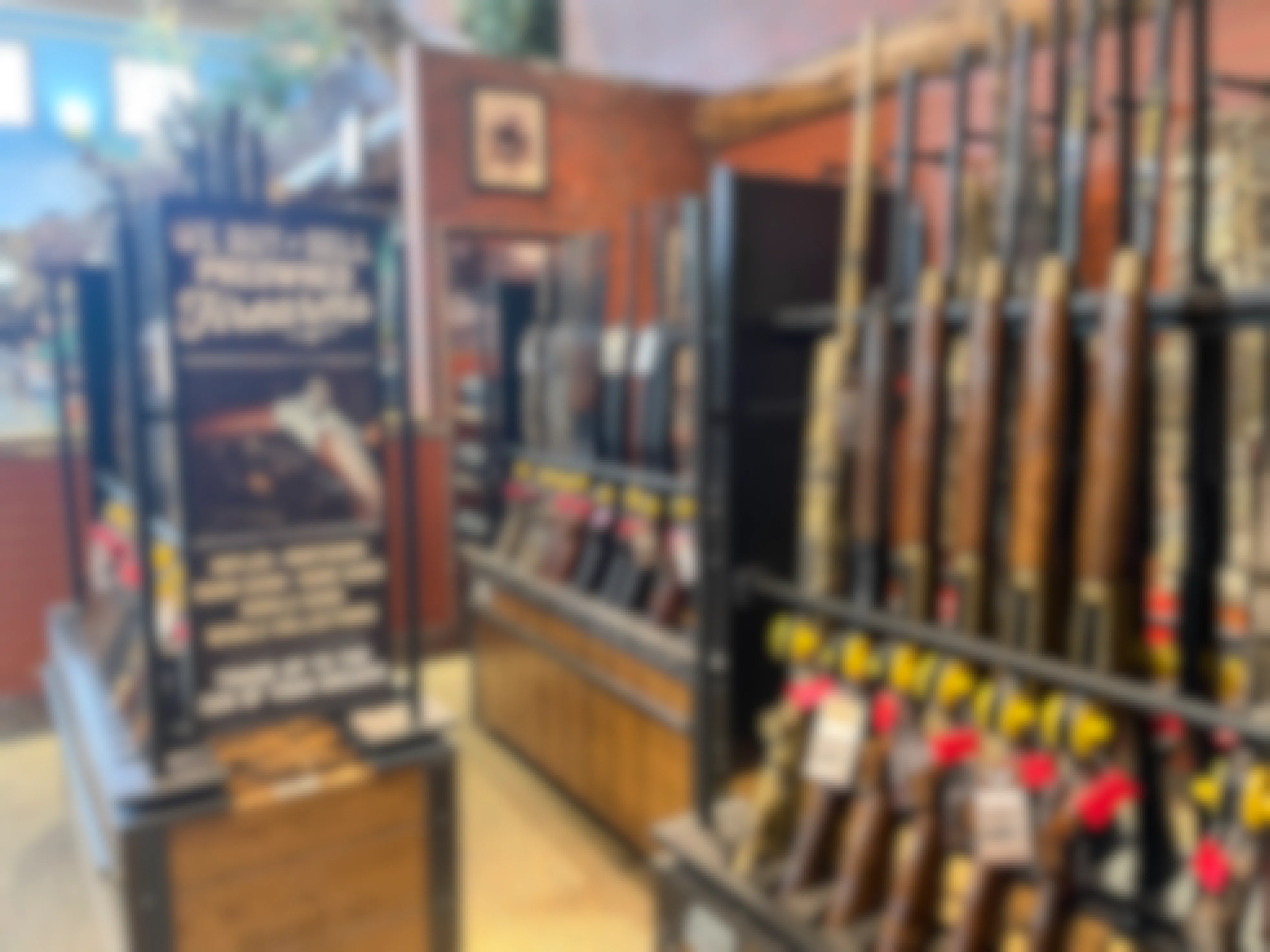 The firearm display inside Cabela's next to a sign that reads, "We buy & sell preowned firearms