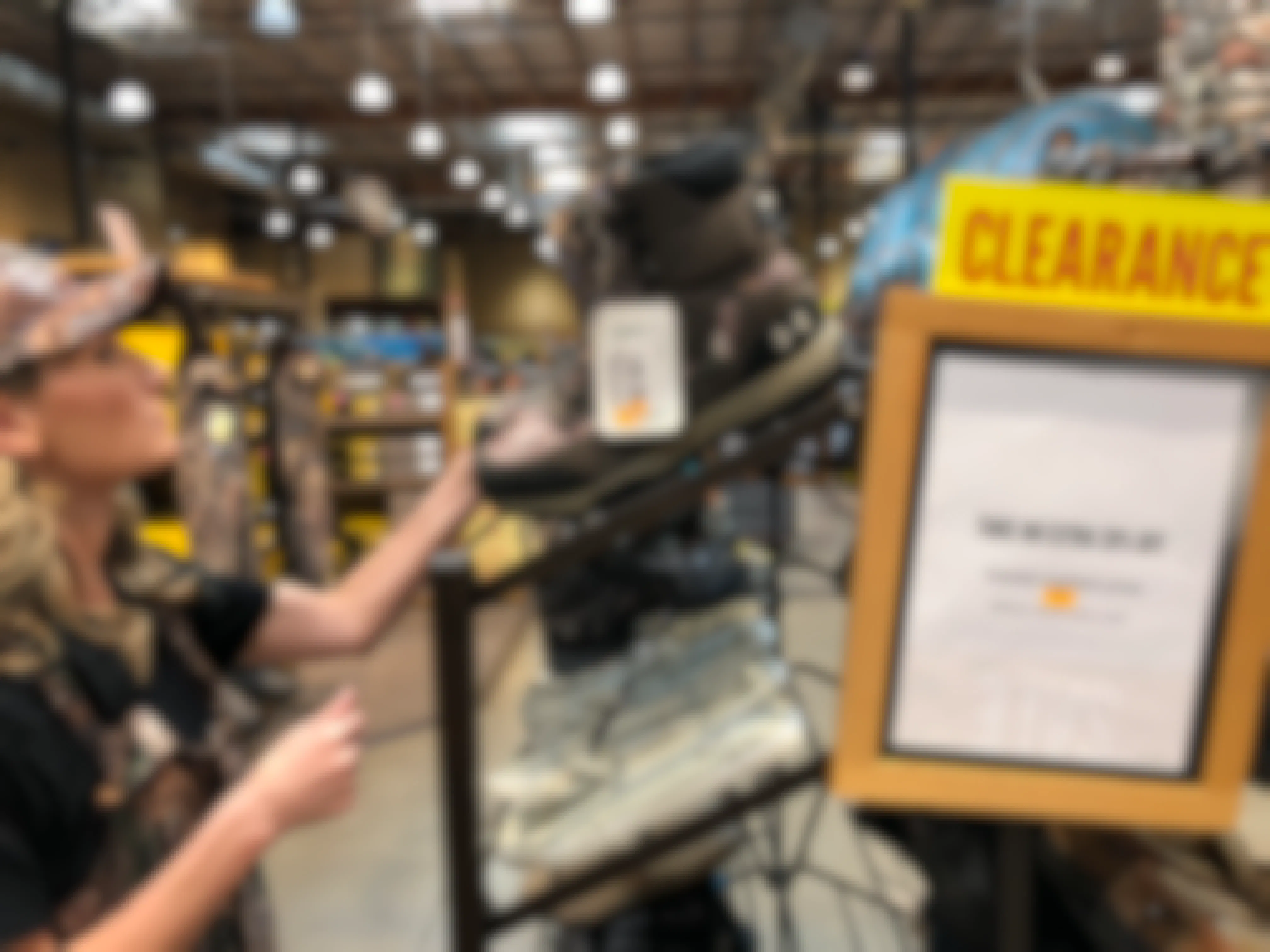 A woman looking at clearance boots on a shelf in Cabela's.