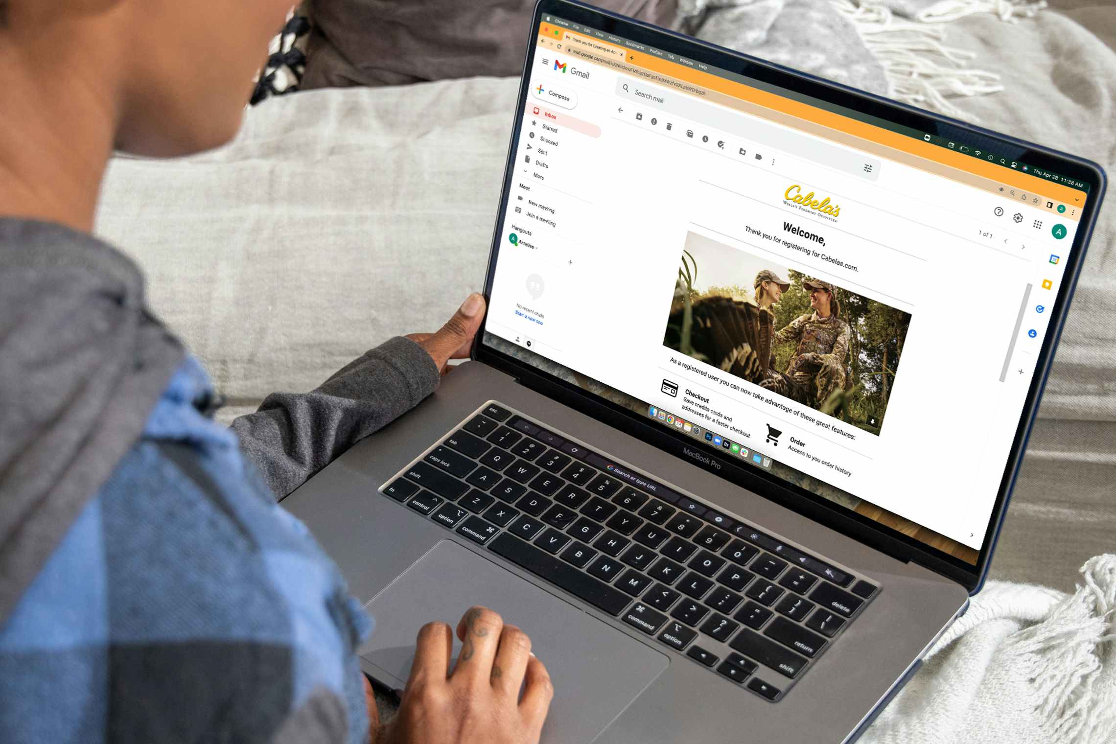 A person using a laptop, looking at a welcome email from Cabela's.