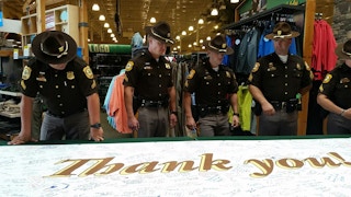 A group of law enforcement standing inside a Cabela's store.