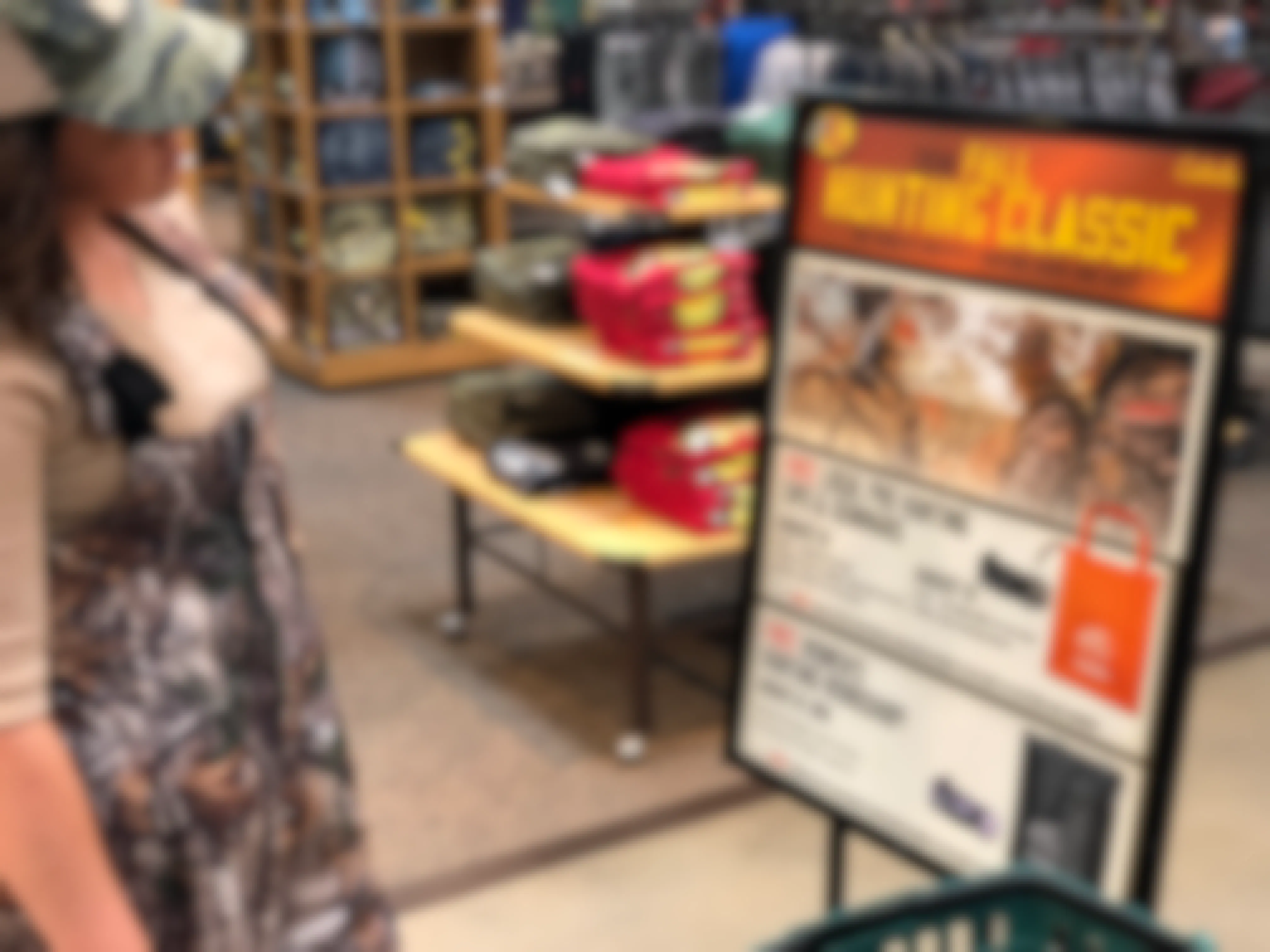 A woman looking at a sign inside Cabela's that is advertising their free hunting classes.