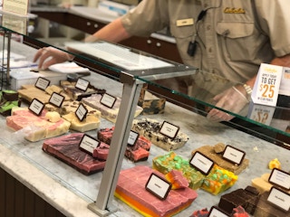 An employee working at the fudge display counter inside Cabela's