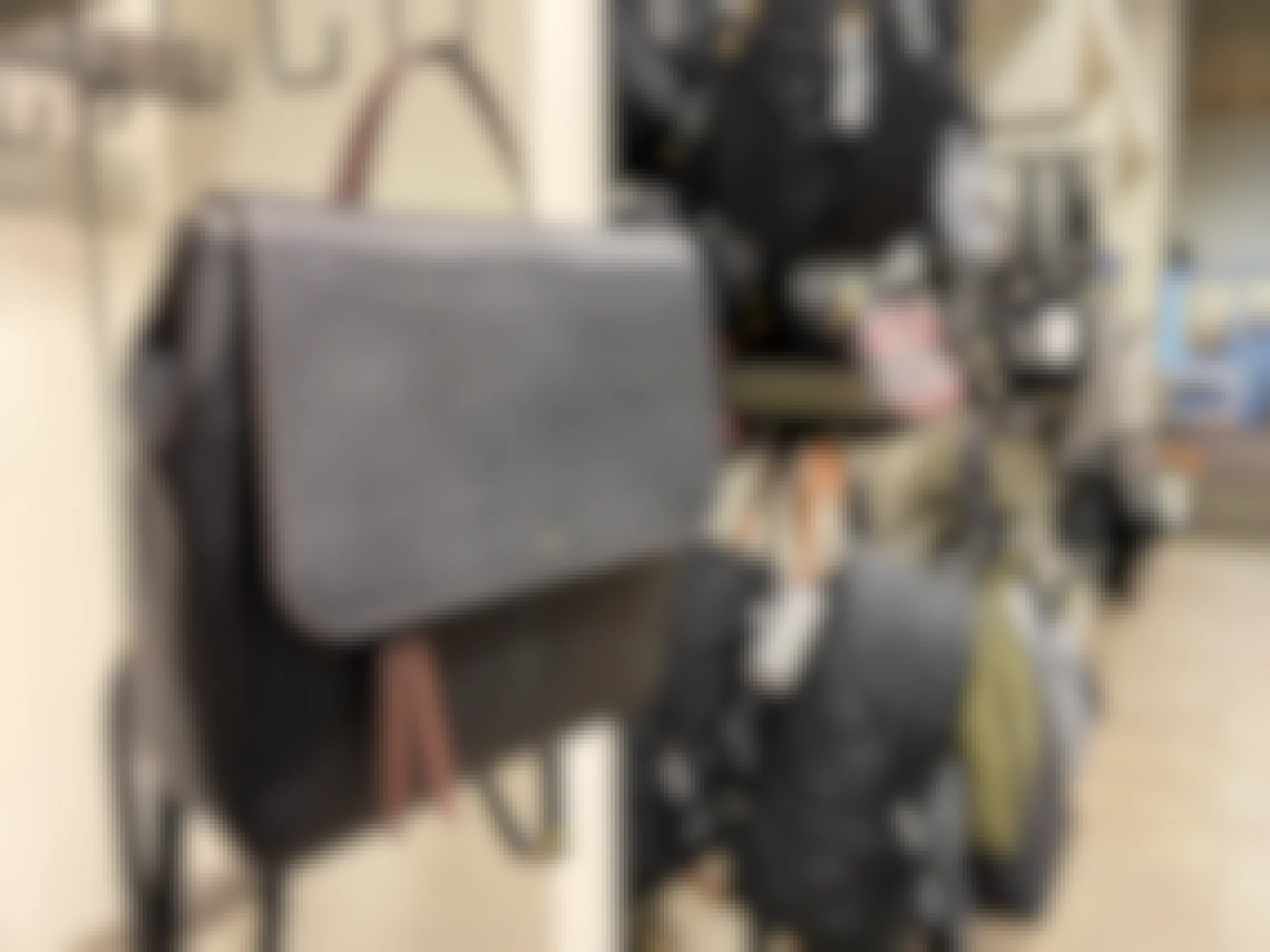 A fossil bag with other purses and backpacks hung on hooks inside a DSW store.